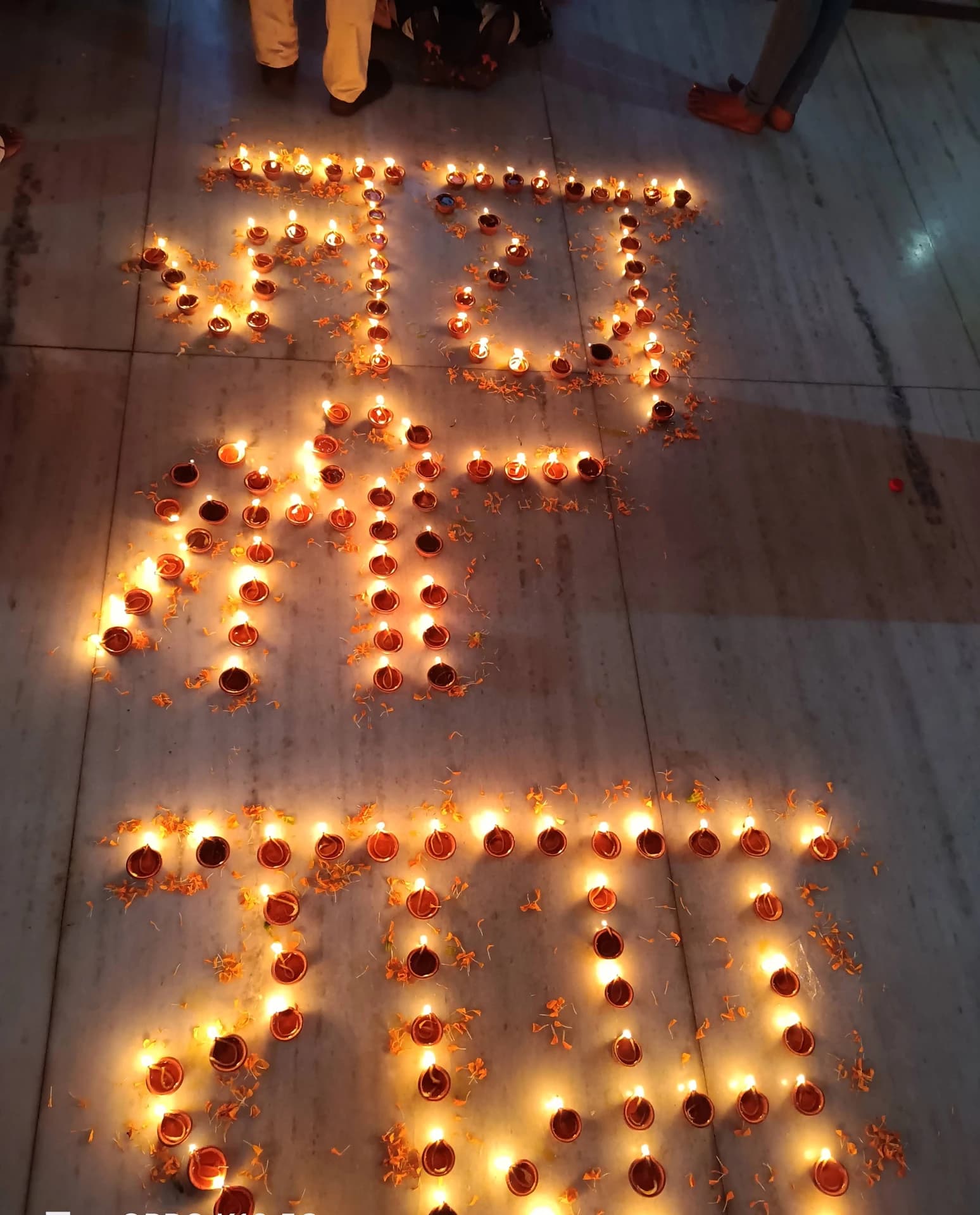 Rows of oil lamps arranged on the stone floor of Sri Venkateswara Swamy Temple, Alipurduar Junction.
