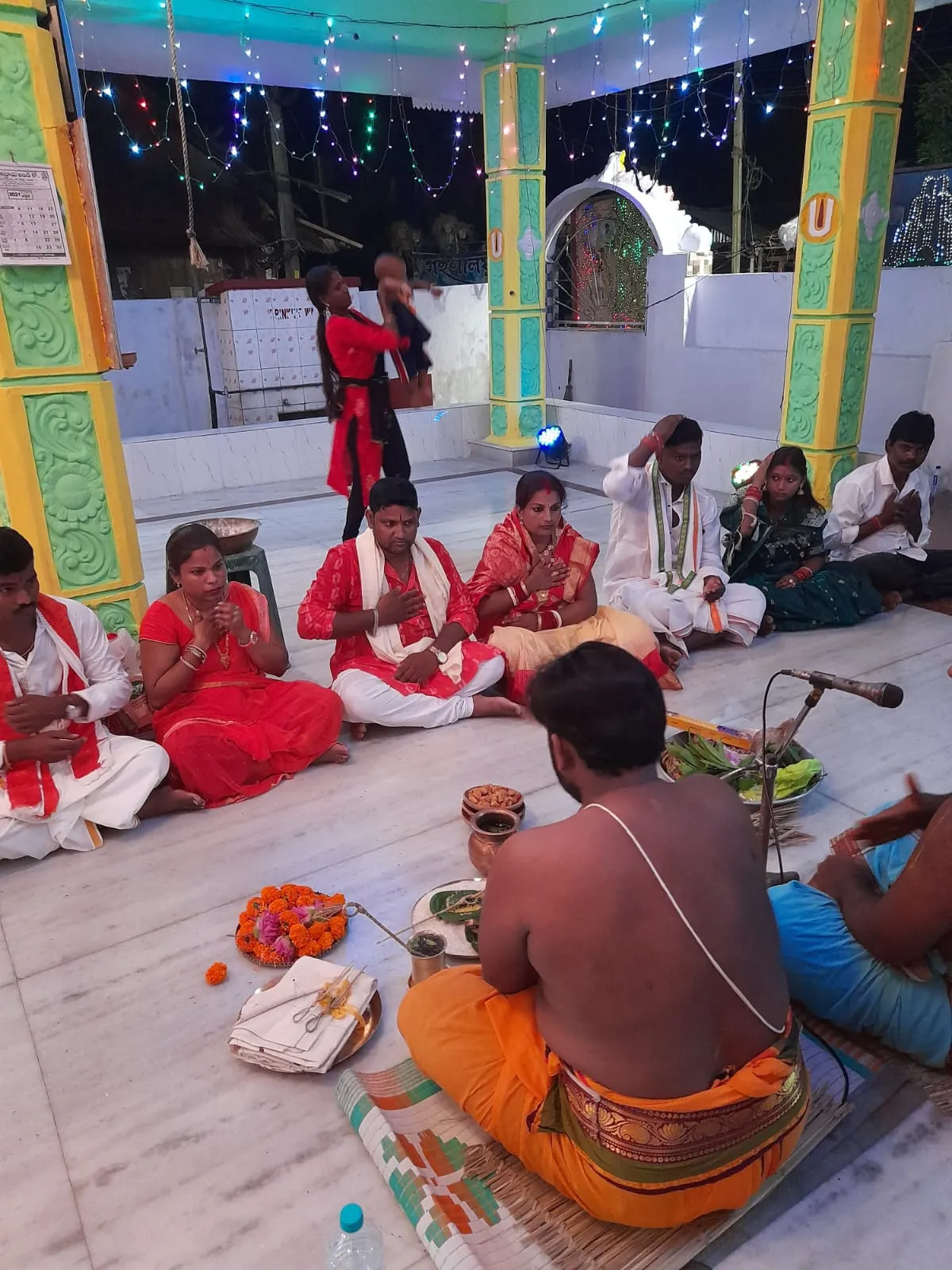 Devotees seated for worship in the temple pavilion at Sri Venkateswara Swamy Temple, Alipurduar