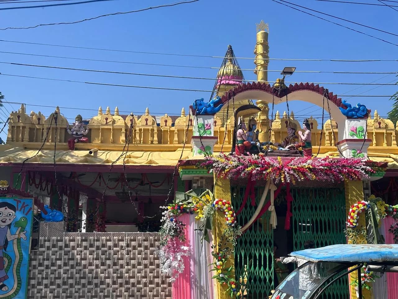 Rail Bazaar, আলিপুরদুয়ারে শ্রী ভেঙ্কটেশ্বর স্বামী মন্দিরের প্রধান প্রবেশদ্বার, সাজানো খিলান ও সোনালি ধ্বজস্তম্ভসহ