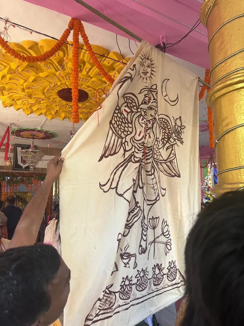 Hand-painted ceremonial banner with a Garuda figure, shown inside Sri Venkateswara Swamy Temple