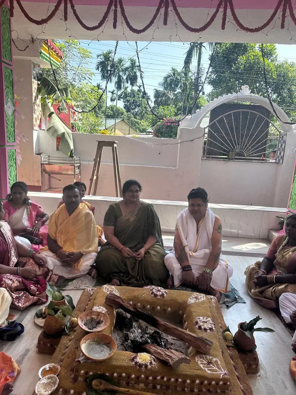 Devotees seated around a ceremonial fire on the veranda of Sri Venkateswara Swamy Temple